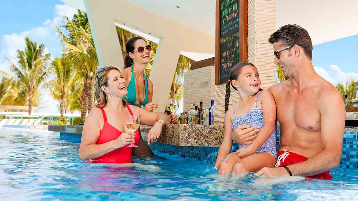 Family time having fun at the swim up bar at Generations Riviera Maya in Cancun